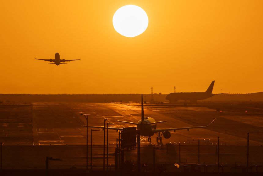A plane takes off from the runway as another plane makes a stop at Los Angeles International Airport on March 9, 2026.